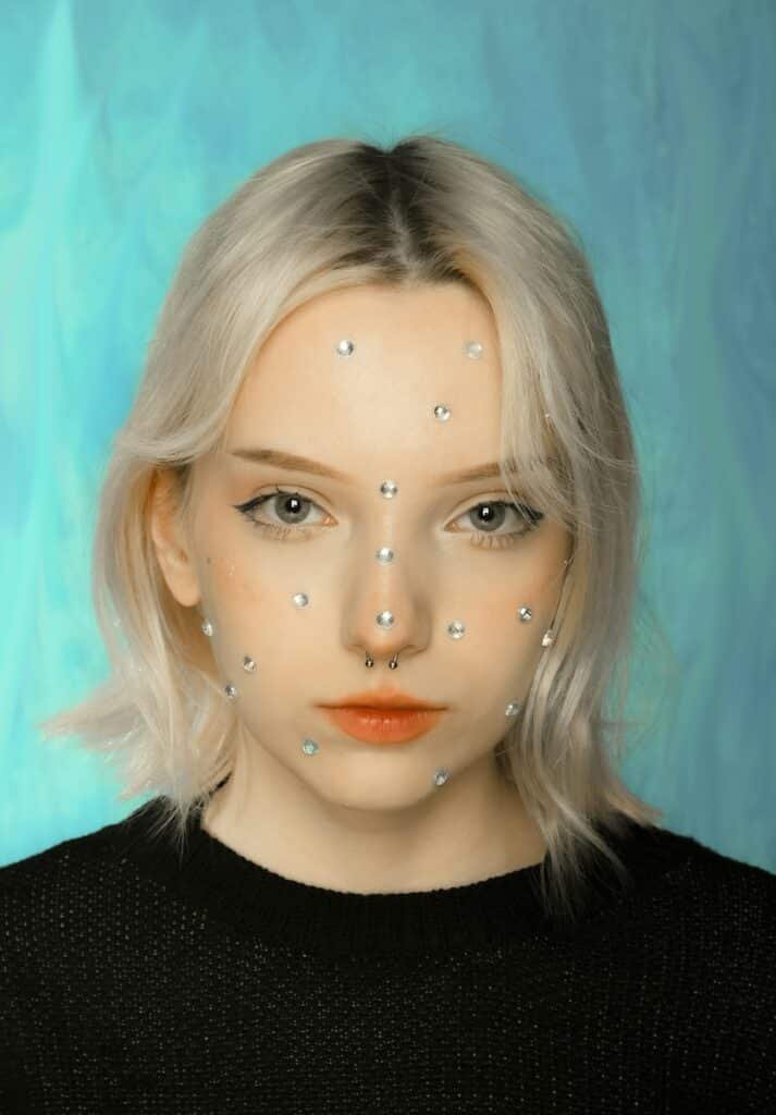 a woman with white hair and pearls on her face