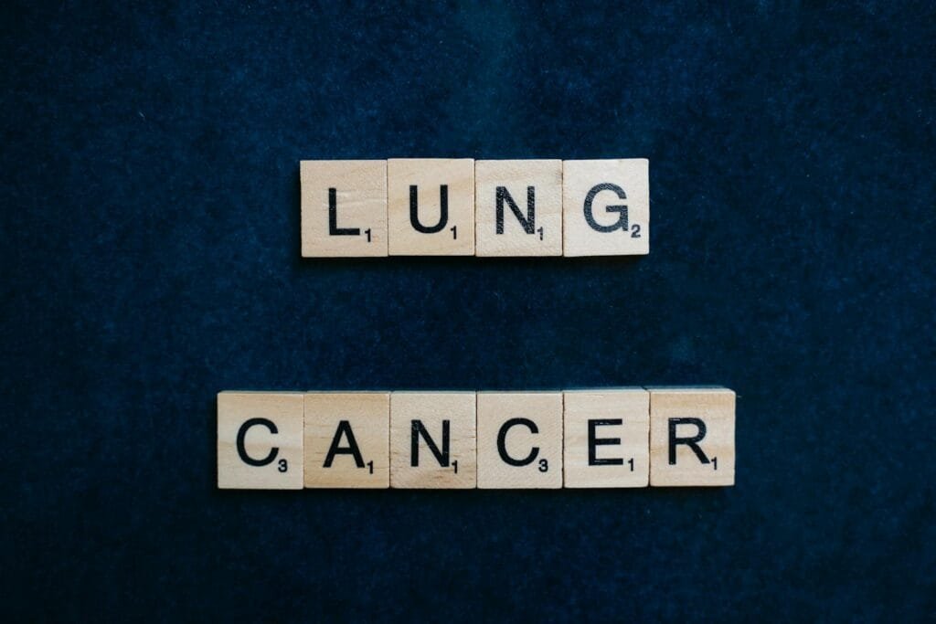 Scrabble tiles spelling lung cancer on dark background symbolizing awareness.