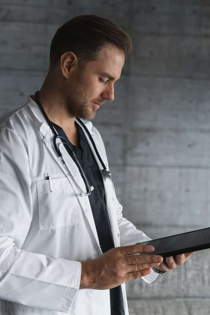 man in white button up shirt holding black tablet computer