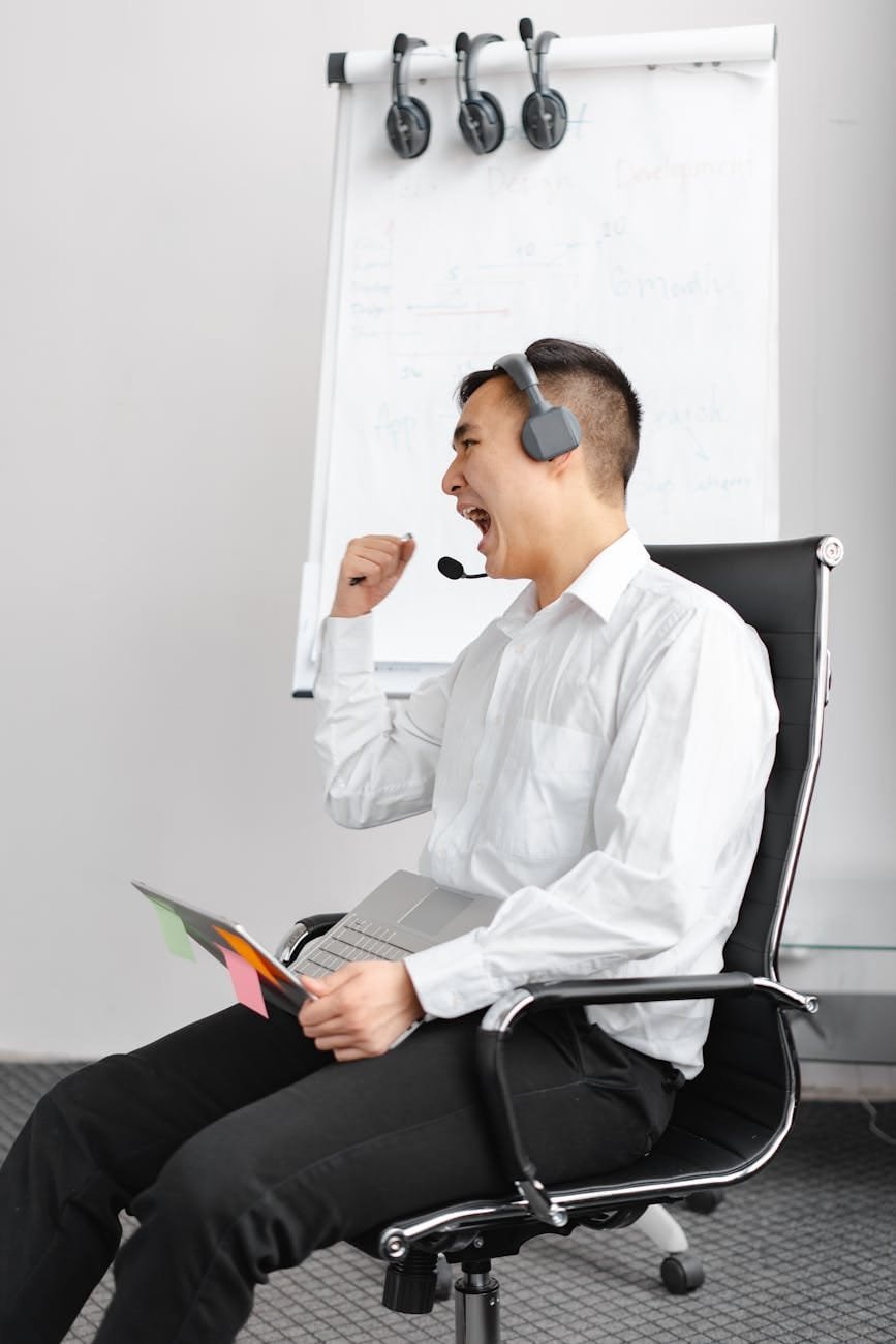 man with a headset holding his laptop